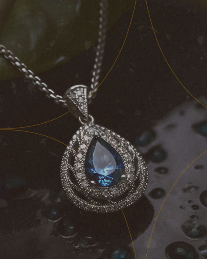 Collier serti d’une pierre bleue, sur fond sombre et texturé. Image élégante et intemporelle pour la marque Ozun Joaillerie, créée par Grow with Design.